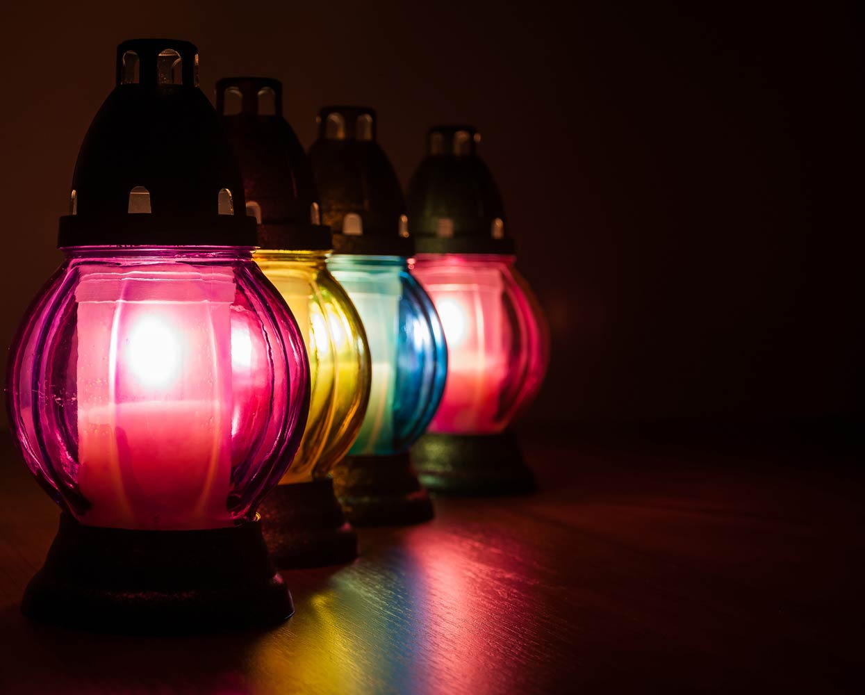 closeup of burning votive candles in the dark