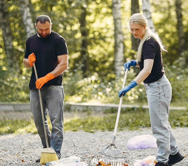 couple removing rubbish from garden